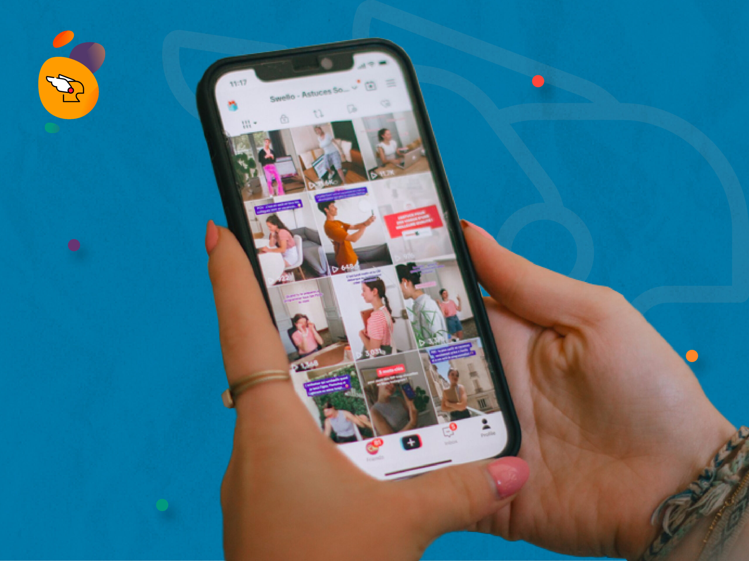 Seseorang sedang menggenggam smartphone yang menampilkan halaman analisis tren video melalui TTMS (TikTok Marketscope) dengan latar belakang biru.