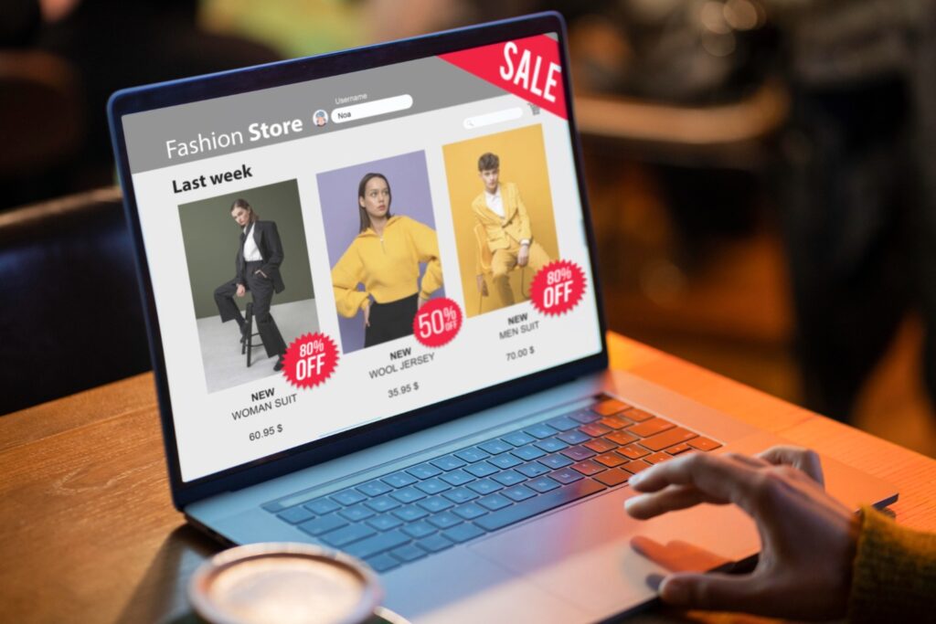 seseorang sedang berbelanja pakaian secara online lewat laptop