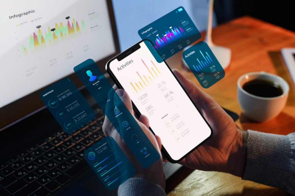 seseorang sedang memantau data infografik di ponsel dan laptop